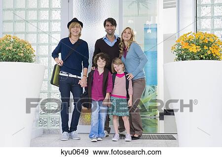 Stock Photo - Couple with their children and a nanny at the door of a house. Fotosearch