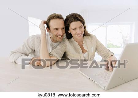 Stock Photo - Couple working on a laptop. Fotosearch