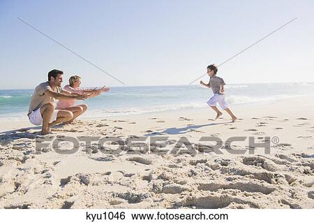 Stock Photograph - Family enjoying vacations on the beach. Fotosearch