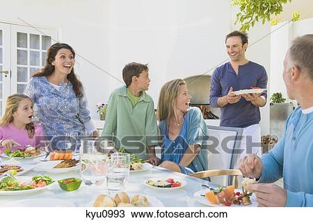 Stock Image - Family having breakfast at the dining table. Fotosearch