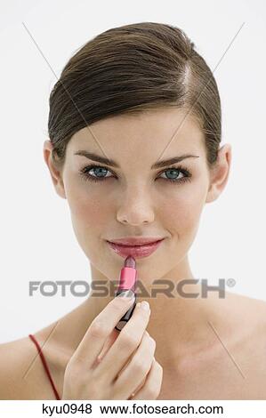 Fashion model applying lipstick on her lips View Large Photo Image Stock Photo - Fashion model applying lipstick on her lips. Fotosearch