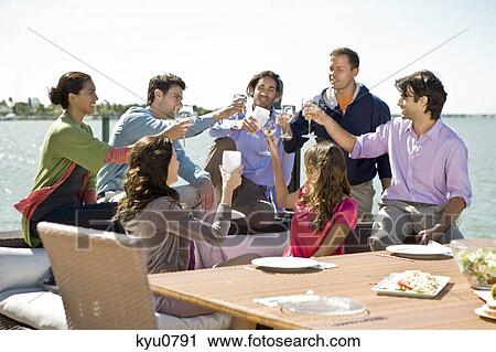 Friends toasting with drinks at a party View Large Photo Image Stock Image - Friends toasting with drinks at a party. Fotosearch