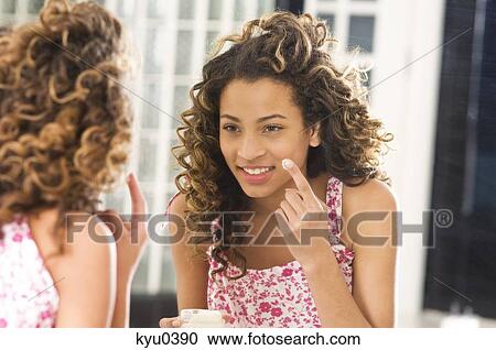 Girl applying moisturizer on her face View Large Photo Image Stock Image - Girl applying moisturizer on her face. Fotosearch