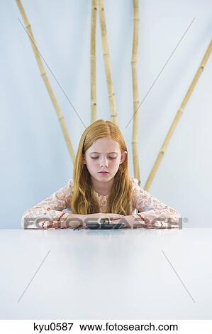 Stock Photo - Girl at the dining table. Fotosearch