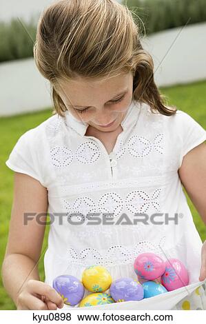 Girl carrying Easter eggs View Large Photo Image Stock Photo - Girl carrying Easter eggs. Fotosearch