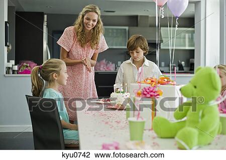 Stock Image - Girl celebrating her birthday with her family. Fotosearch