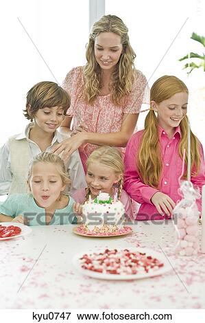 Girl celebrating her birthday with her mother and friends View Large Photo Image Stock Photo - Girl celebrating her birthday with her mother and friends. Fotosearch
