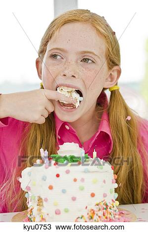 Stock Image - Girl eating birthday cake. Fotosearch