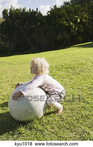 Girl playing with a round stone View Large Photo Image Stock Photo - Girl playing with a round stone. Fotosearch