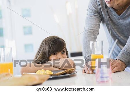 Stock Photo - Girl with her father at the breakfast table. Fotosearch