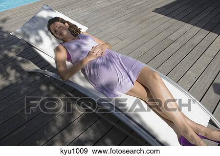 Stock Photo - High angle view of a woman resting on a deck chair. Fotosearch