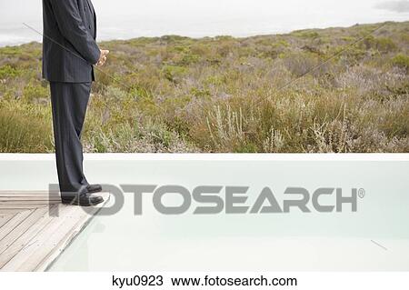 Low section view of a businessman standing on a platform at an infinity pool View Large Photo Image Stock Image - Low section view of a businessman standing on a platform at an infinity pool. Fotosearch