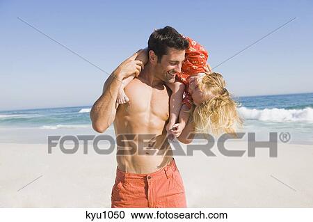 Man carrying his daughter on his shoulders on the beach View Large Photo Image Stock Image - Man carrying his daughter on his shoulders on the beach. Fotosearch