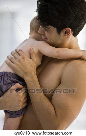Stock Image - Man carrying his son. Fotosearch