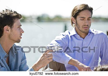 Man enjoying drink with his friend View Large Photo Image Stock Image - Man enjoying drink with his friend. Fotosearch