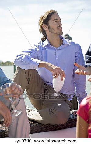Man enjoying drinks with his friend at a party View Large Photo Image Stock Image - Man enjoying drinks with his friend at a party. Fotosearch