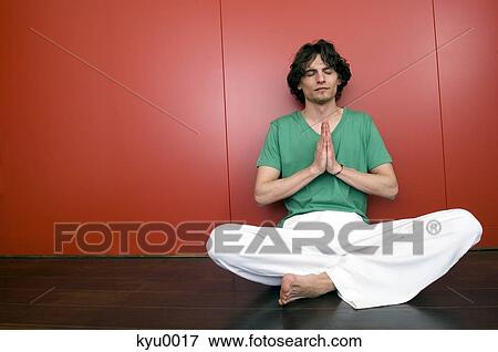 Stock Photo - Man in yoga position, sitting cross-legged. Fotosearch