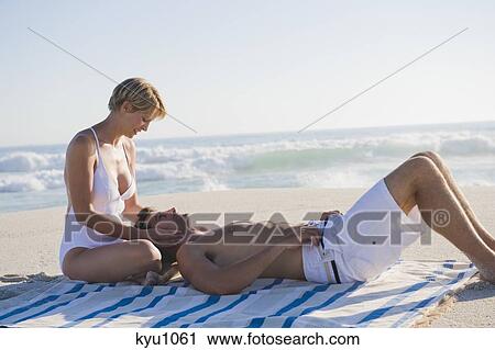 Man lying on woman's lap on the beach View Large Photo Image Stock Image - Man lying on woman's lap on the beach. Fotosearch