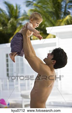 Stock Image - Man picking his son up. Fotosearch