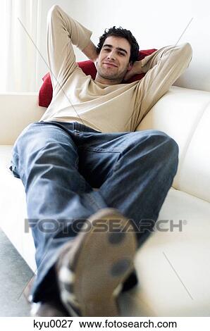 Man resting, lying on a sofa View Large Photo Image Stock Photo - Man resting, lying on a sofa. Fotosearch