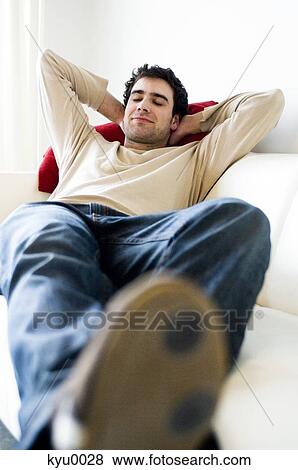 Man resting, lying on a sofa View Large Photo Image Stock Photo - Man resting, lying on a sofa. Fotosearch
