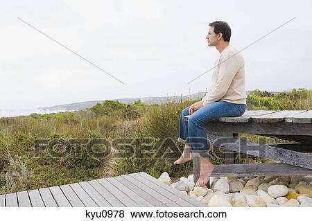 Man sitting on a boardwalk and thinking View Large Photo Image Stock Photo - Man sitting on a boardwalk and thinking. Fotosearch