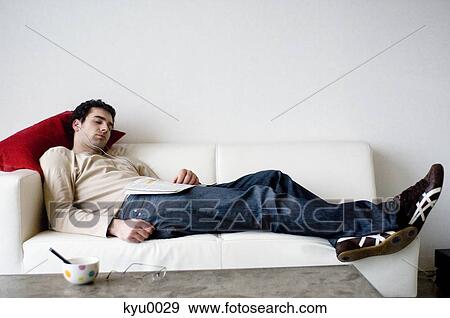 Stock Photo - Man sleeping on a sofa. Fotosearch