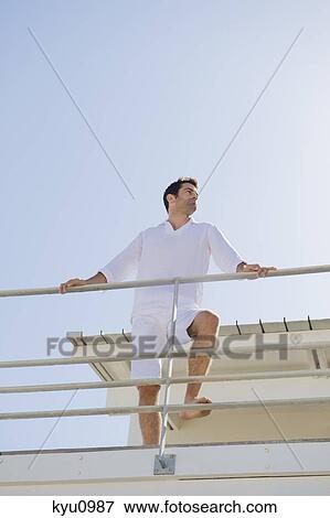 Man standing on the beach house View Large Photo Image Stock Photo - Man standing on the beach house. Fotosearch