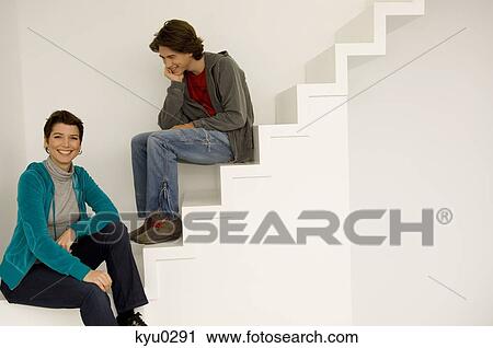 Mid adult woman and her son sitting on a staircase View Large Photo Image Stock Image - Mid adult woman and her son sitting on a staircase. Fotosearch