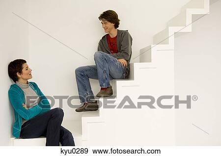 Mid adult woman and her son sitting on a staircase View Large Photo Image Stock Photo - Mid adult woman and her son sitting on a staircase. Fotosearch