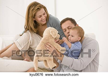 Stock Photograph - Parents playing with their daughter. Fotosearch