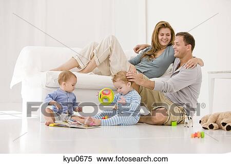 Stock Photography - Parents with their son and a daughter in a living room. Fotosearch