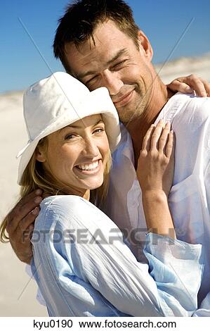 Portrait of a couple embracing, on the beach View Large Photo Image Stock Image - Portrait of a couple embracing, on the beach. Fotosearch