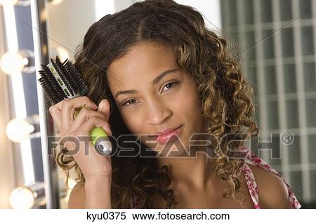 Portrait of a girl brushing her hair View Large Photo Image Stock Photography - Portrait of a girl brushing her hair. Fotosearch