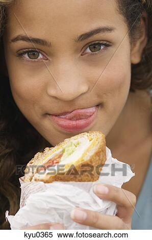 Portrait of a girl eating a sandwich View Large Photo Image Stock Photography - Portrait of a girl eating a sandwich. Fotosearch