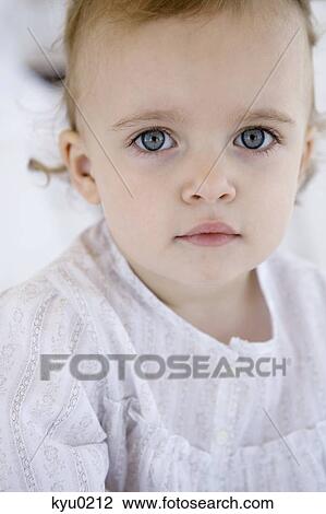 Stock Image - Portrait of a little girl posing for the camera. Fotosearch