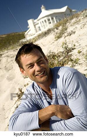 Portrait of a man smiling, sittin on the beach View Large Photo Image Stock Photo - Portrait of a man smiling, sittin on the beach. Fotosearch
