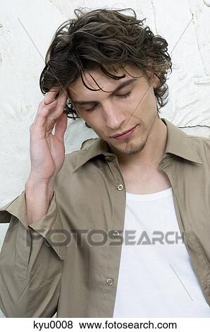 Stock Photo - Portrait of a man with hand on temple. Fotosearch