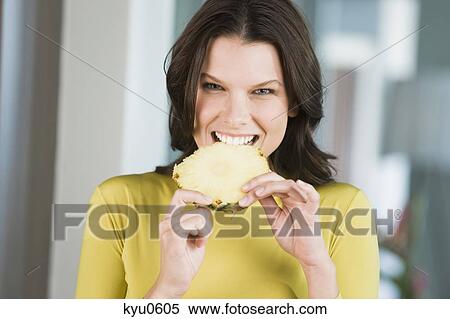 Portrait of a woman eating a slice of pineapple View Large Photo Image Stock Photography - Portrait of a woman eating a slice of pineapple. Fotosearch