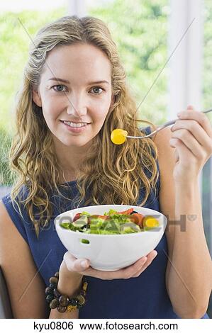 Portrait of a woman eating fruit salad View Large Photo Image Stock Photograph - Portrait of a woman eating fruit salad. Fotosearch