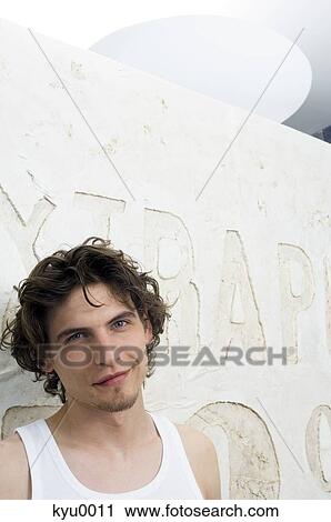 Stock Image - Portrait of a young man smiling at the camera. Fotosearch