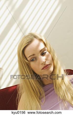 Stock Photograph - Portrait of a young thinking woman, blond hair. Fotosearch