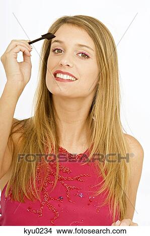 Portrait of a young woman applying make-up View Large Photo Image Picture - Portrait of a young woman applying make-up. Fotosearch