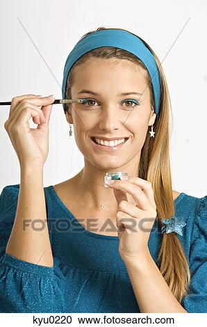 Portrait of a young woman applying eyeshadow View Large Photo Image Stock Image - Portrait of a young woman applying eyeshadow. Fotosearch