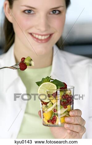 Portrait of a young woman eating fruit salad View Large Photo Image Stock Image - Portrait of a young woman eating fruit salad. Fotosearch