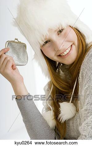 Picture - Portrait of a young woman holding a purse and smiling. Fotosearch