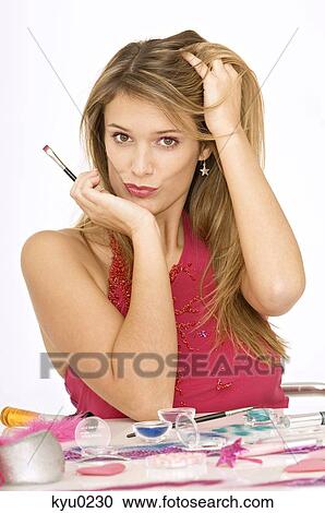 Portrait of a young woman holding a make-up brush View Large Photo Image Stock Image - Portrait of a young woman holding a make-up brush. Fotosearch