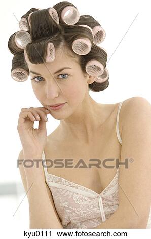 Stock Image - Portrait of a young woman in curlers. Fotosearch