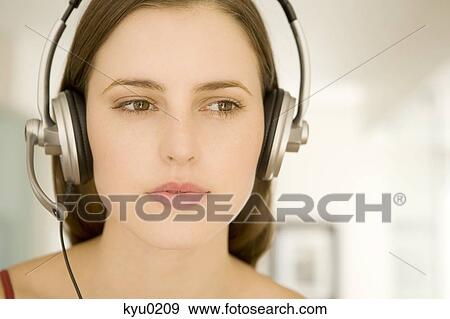Portrait of a young woman, listening to music with headphones View Large Photo Image Stock Photo - Portrait of a young woman, listening to music with headphones. Fotosearch