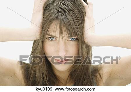 Portrait of a young woman looking at the camera, hands on head View Large Photo Image Stock Photo - Portrait of a young woman looking at the camera, hands on head. Fotosearch